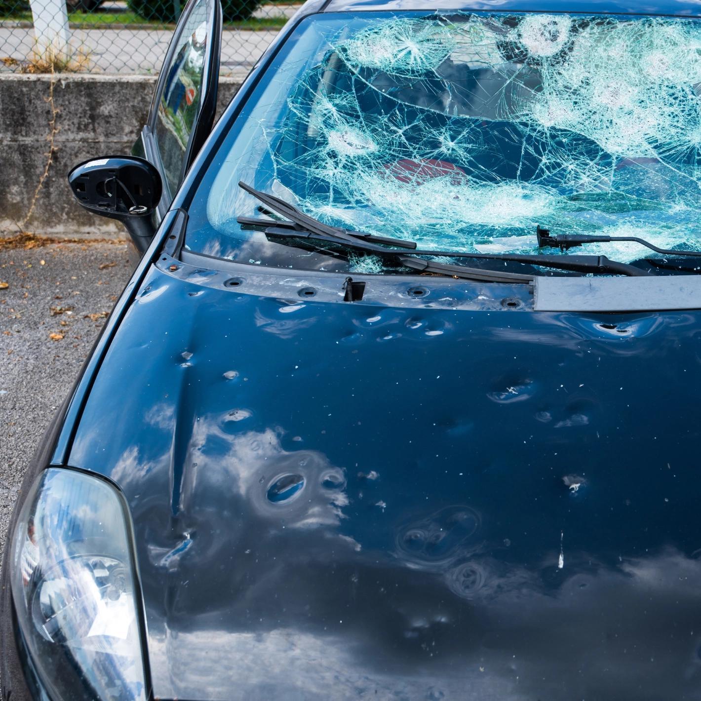 Cofano e parabrezza di automobile danneggiati dalla grandine