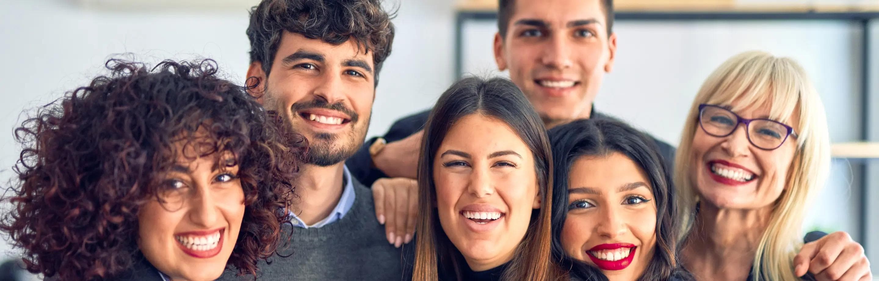 Gruppo di dipendenti Car Clinic abbracciati che sorridono